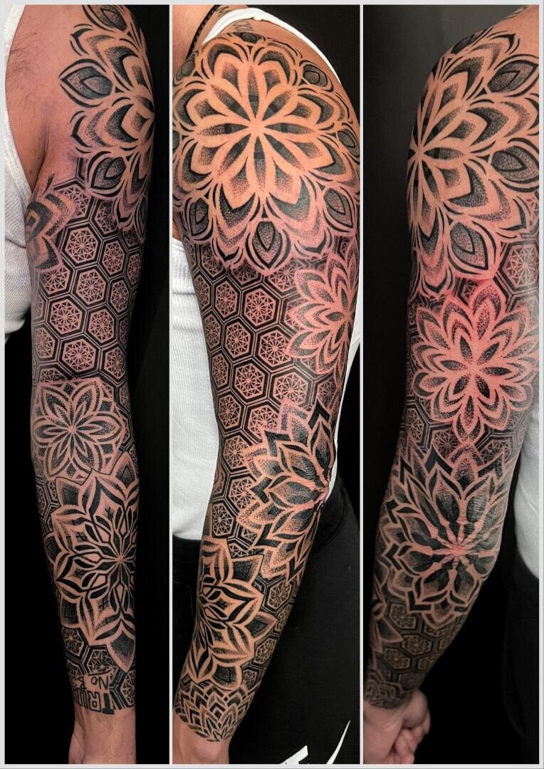 Eine Ganzarmtätowierung mit komplizierten geometrischen Mustern und großen mandalaförmigen Blumenmustern, die aus drei verschiedenen Winkeln auf dem Arm einer Person gezeigt werden.