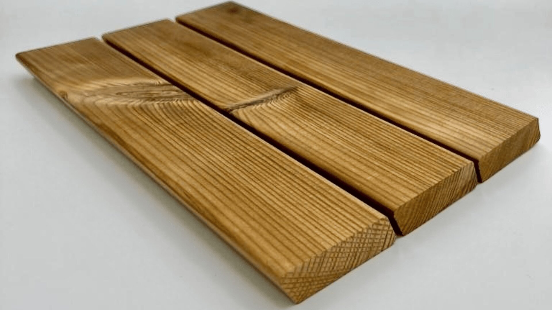 Drei parallele Holzbretter mit glatter, natürlicher Maserung und abgeschrägten Kanten sind nebeneinander auf einer weißen Oberfläche angeordnet.