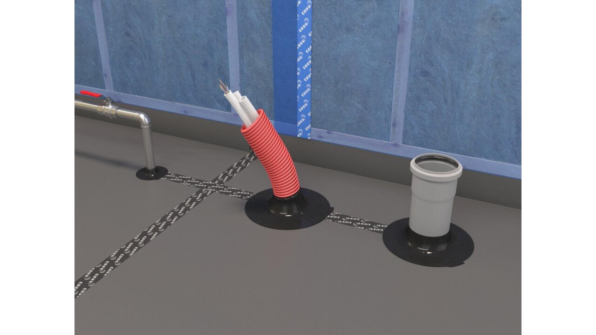 A close-up of a floor with two circular pipe penetrations: one with a red conduit carrying electrical wires, and one gray pipe, both sealed at the base. Blue insulated wall panels are visible in the background.