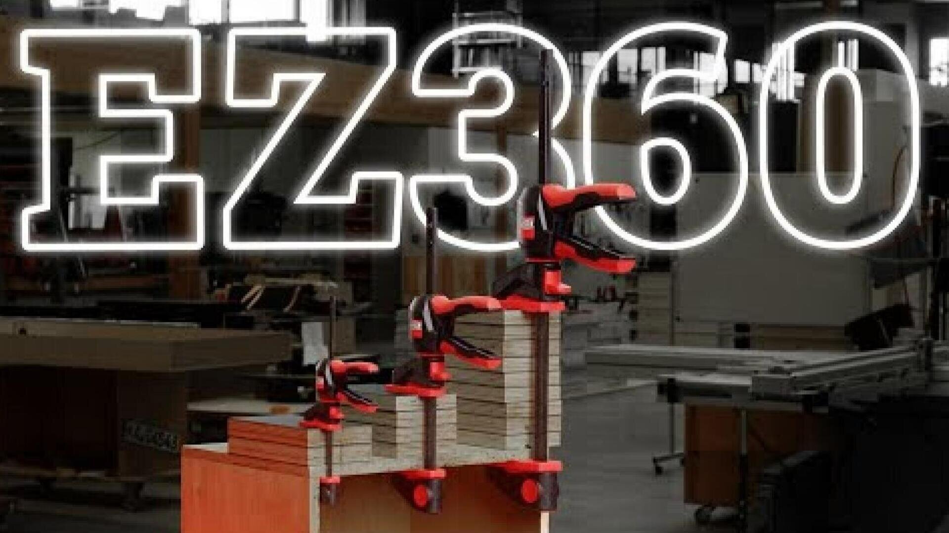 Ein Stapel Holzbretter, die mit roten und schwarzen Zwingen in einer Werkstatt zusammengeklemmt sind. Der große, durchscheinende Text EZ360 wird quer über das Bild angezeigt.