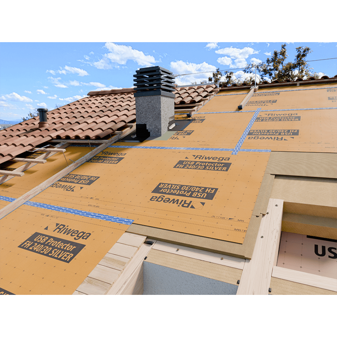 Ein im Bau befindliches Schrägdach mit teilweise verlegten braunen Ziegeln, Schutzfolien mit der Aufschrift RIWEGA USB Protector, die Abschnitte abdecken, und ein Schornstein, der vor einem blauen Himmel mit Wolken zu sehen ist.