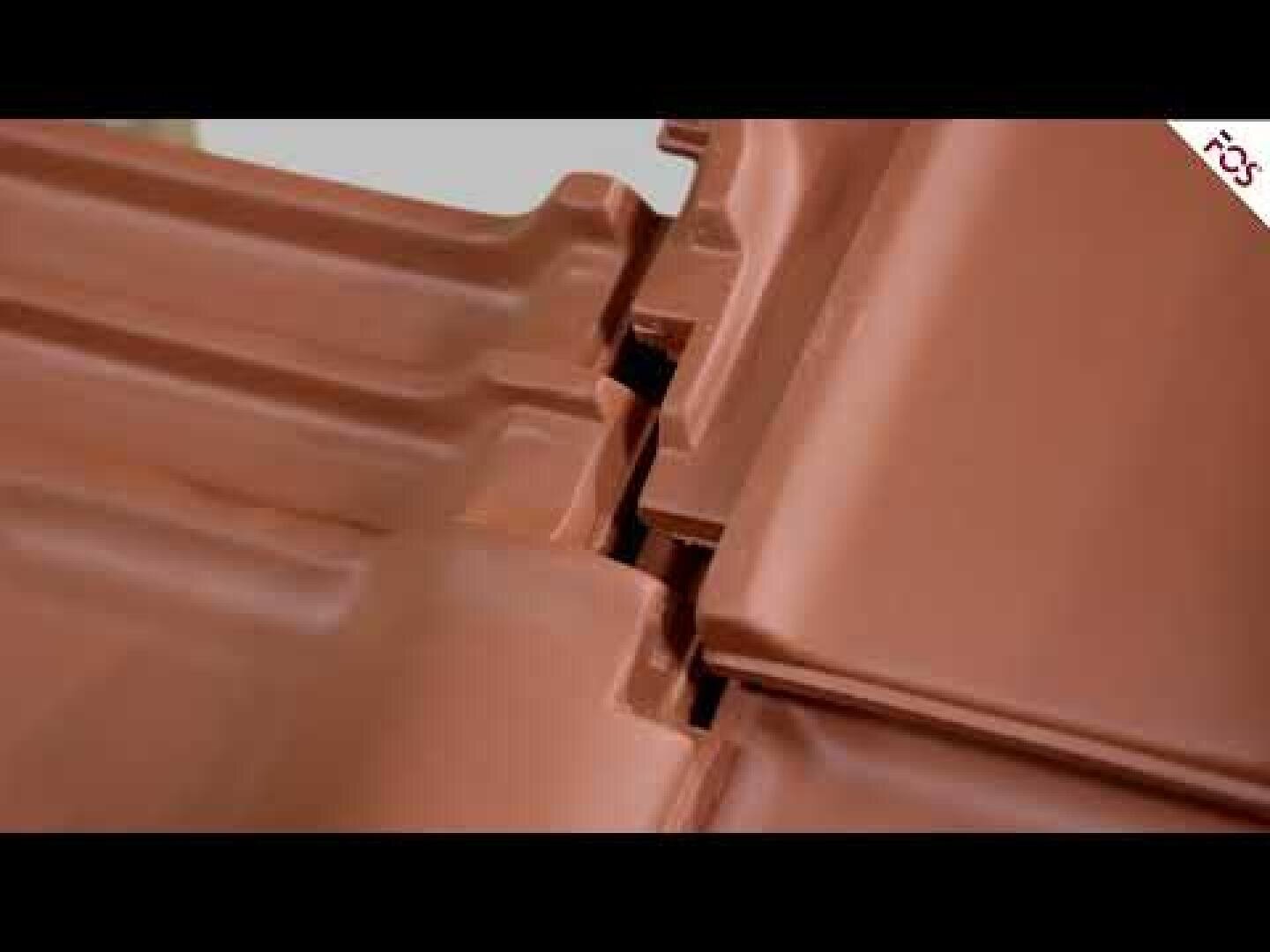 Nahaufnahme von ineinandergreifenden braunen Keramikdachziegeln, die aneinandergereiht sind und deren überlappende Kanten und Verriegelungsmechanismus zeigen.