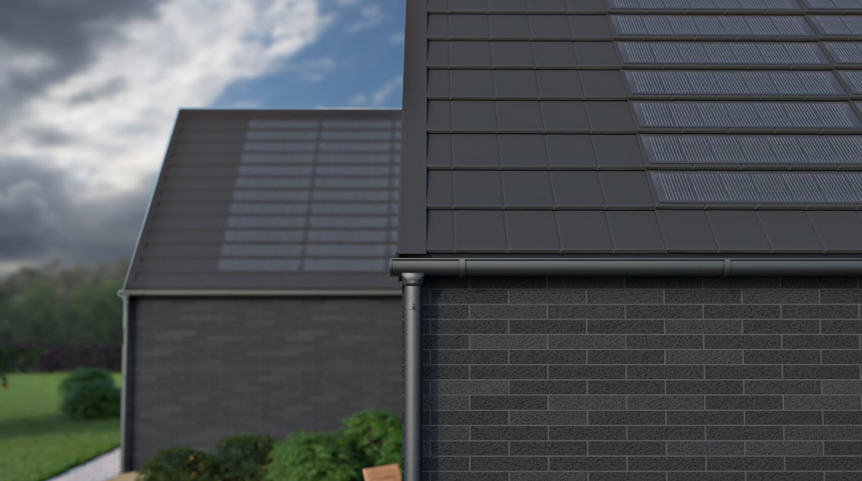Two modern houses with dark brick walls and black tiled roofs, both equipped with solar panels. The foreground shows a close-up of the roof and guttering, while the house in the background is slightly blurred. Shrubs and grass can be seen.